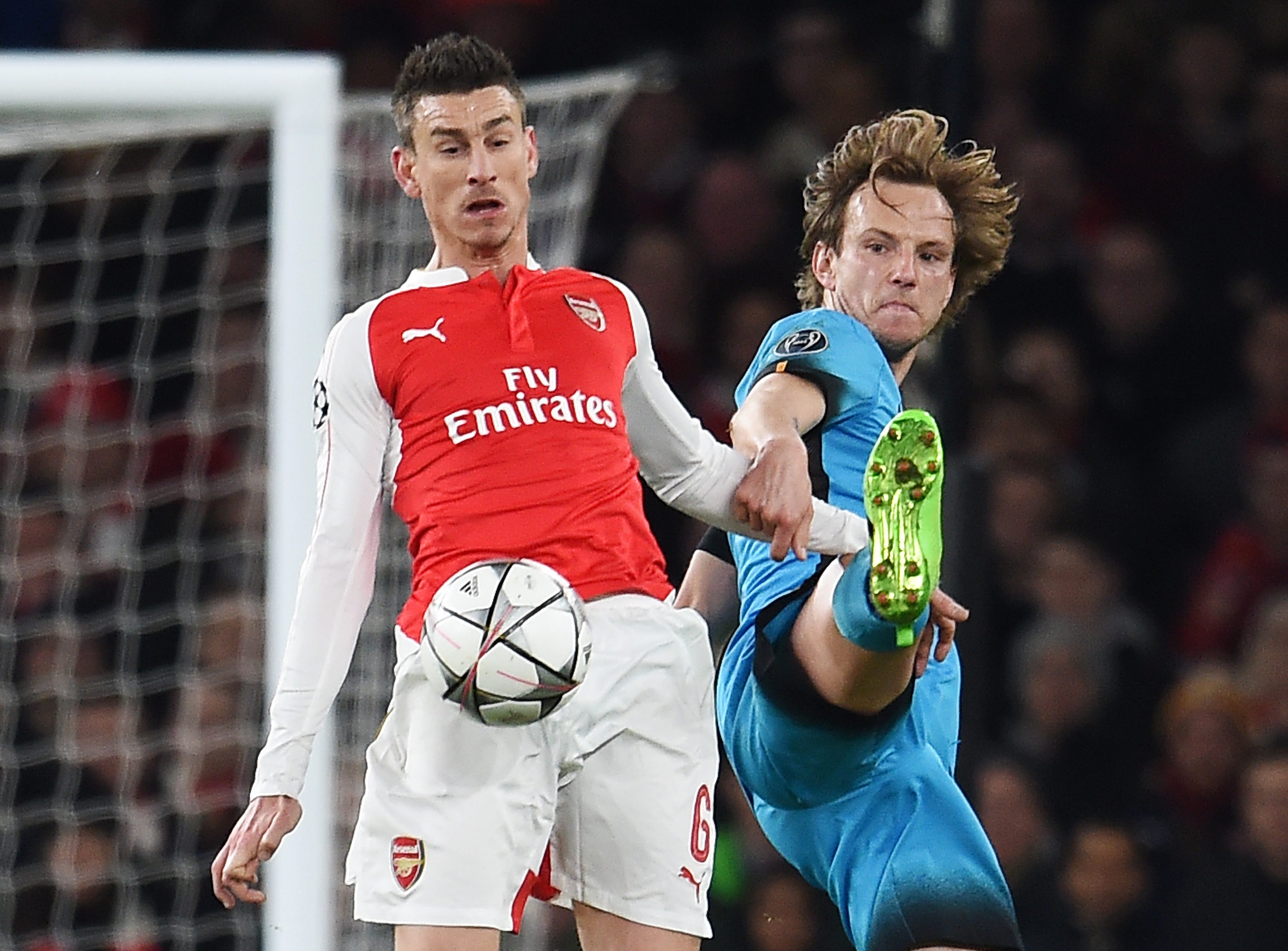Arsenal's Laurent Koscielny (L) vies for the ball with Barcelona's Ivan Rakitic (R) during the UEFA Champions League Round of 16 first leg soccer match between Arsenal and Barcelona at the Emirates Stadium in London, Britain, 23 February 2016. EPA/ANDY RAIN
