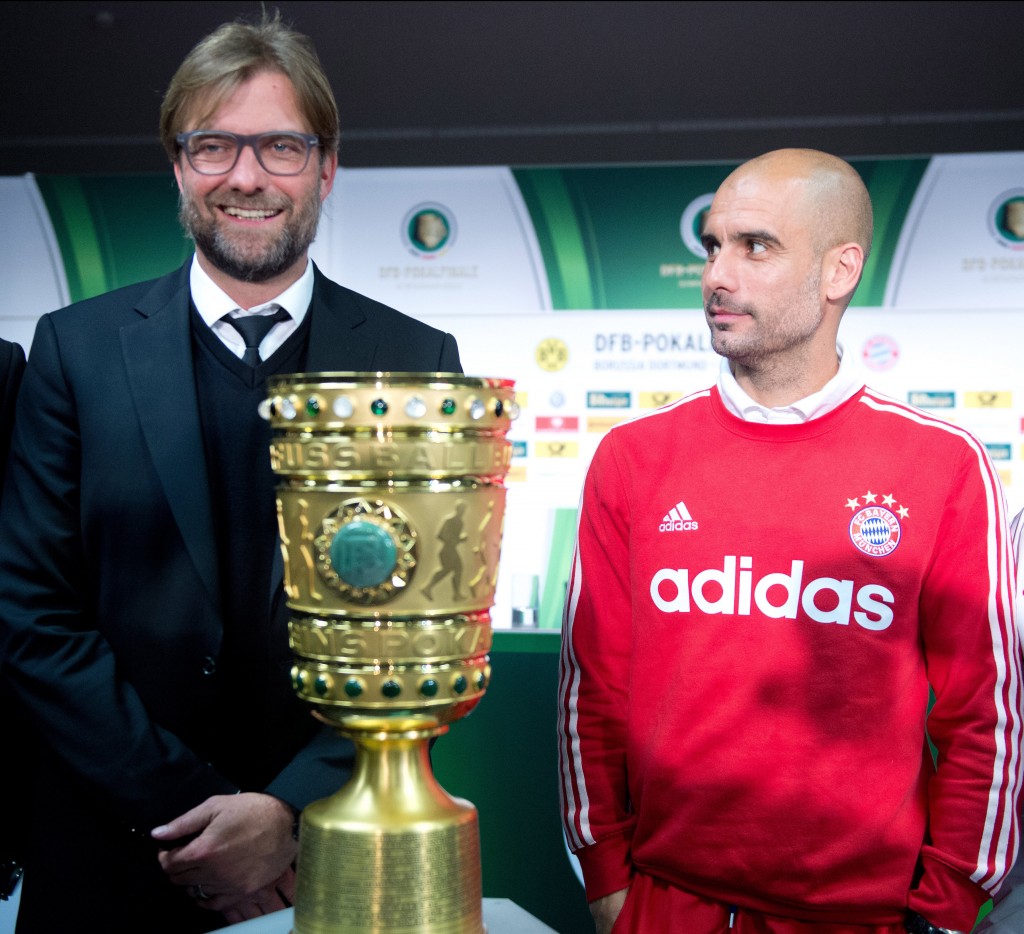 epa04208981 Dortmund's coach Juergen Klopp (L) and Munich's coach Pep Guardiola stand next to the DFB cup during a press conference for the DFB cup final in Berlin, Germany, 16 May 2014. EPA/Maurizio Gambarini