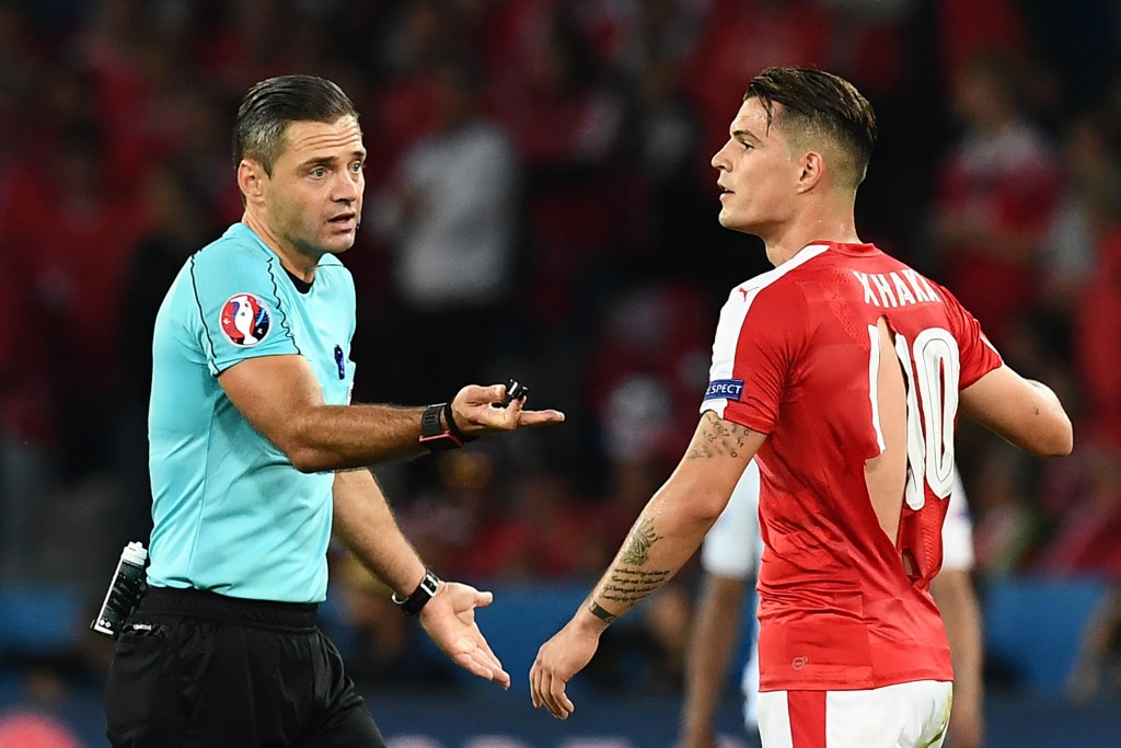 Slovenian referee Damir Skomina gestures towards Switzerland's midfielder Granit Xhaka in a ripped shirt during the Euro 2016 group A football match between Switzerland and France at the Pierre-Mauroy stadium in Lille on June 19, 2016. / AFP / FRANCK FIFE (Photo credit should read FRANCK FIFE/AFP/Getty Images)