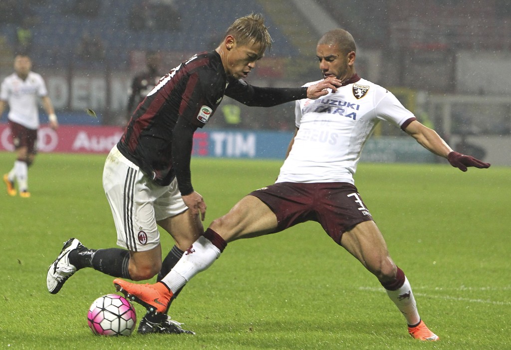 MILAN, ITALY - FEBRUARY 27: Keisuke Honda of AC Milan is challenged by Bruno Peres of Torino FC during the Serie A match between AC Milan and Torino FC at Stadio Giuseppe Meazza on February 27, 2016 in Milan, Italy. (Photo by Marco Luzzani/Getty Images)