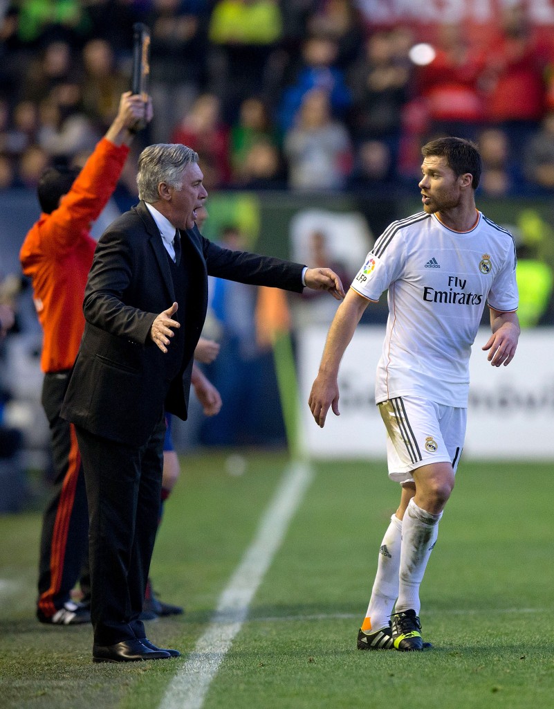 PAMPLONA, SPAIN - DECEMBER 14: Head coach Carlo Ancelotti (L) of Real Madrid CF gives instructions to player Xabi Alonso (R) during the La Liga match between CA Osasuna and Real Madrid CF at Estadio El Sadar de Navarra on December 14, 2013 in Pamplona, Spain. (Photo by Gonzalo Arroyo Moreno/Getty Images)