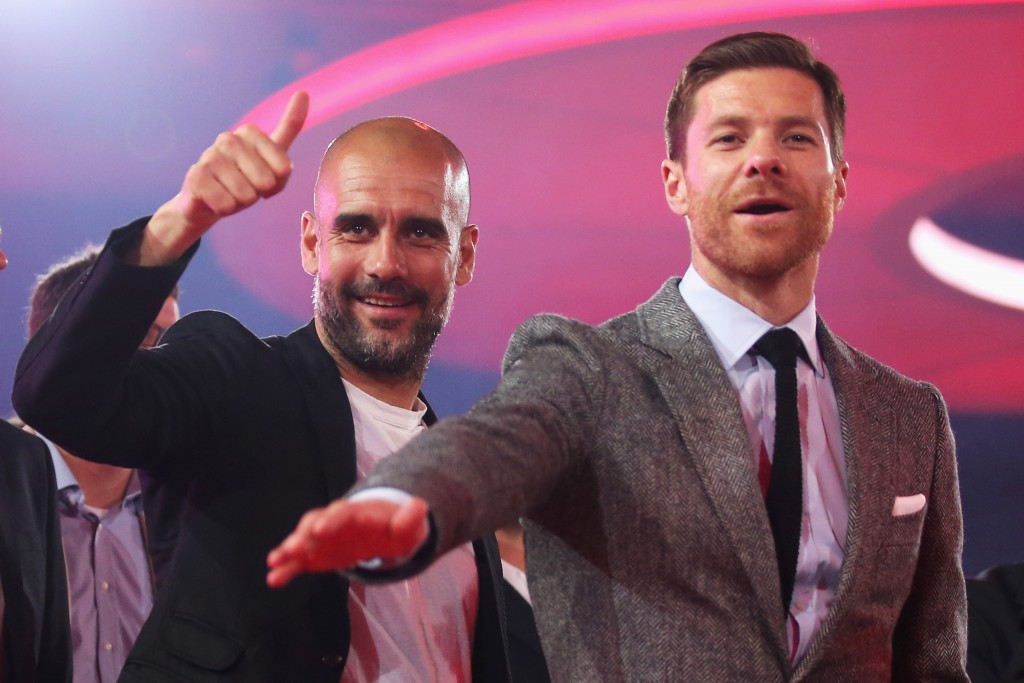 MUNICH, GERMANY - MAY 14: Head Coach, Pep Guardiola (L) and Xabi Alonso wave on stage during the FC Bayern Muenchen Bundesliga Champions Dinner at the Postpalast on May 14, 2016 in Munich, Bavaria. (Photo by Lars Baron/Bongarts/Getty Images)