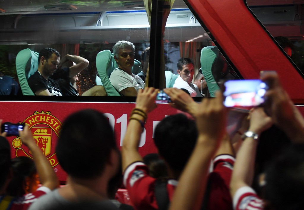 Manchester United coach Jose Mourinho (top C) looks at fans from the team bus after a training session a day before the 2016 International Champions Cup football match between Manchester City and Manchester United, in Beijing on July 24, 2016. / AFP / GREG BAKER (Photo credit should read GREG BAKER/AFP/Getty Images)