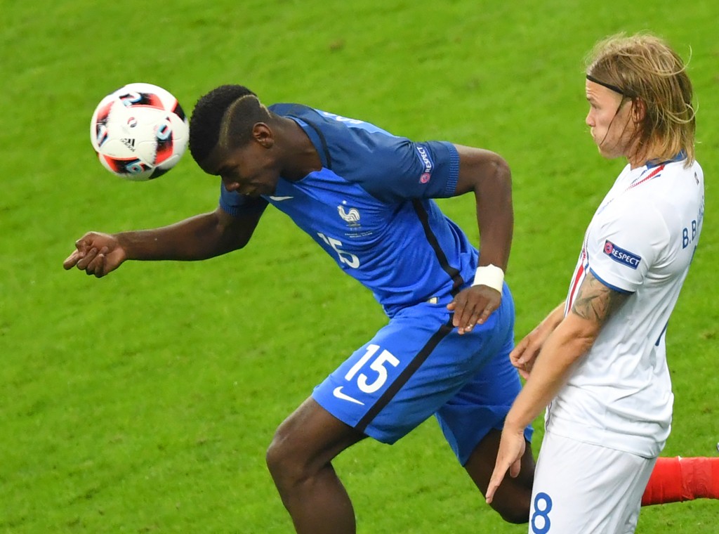 France's midfielder Paul Pogba (L) heads the ball next to Iceland's midfielder Birkir Bjarnason during the Euro 2016 quarter-final football match between France and Iceland at the Stade de France in Saint-Denis, near Paris, on July 3, 2016. / AFP / Francisco LEONG (Photo credit should read FRANCISCO LEONG/AFP/Getty Images)