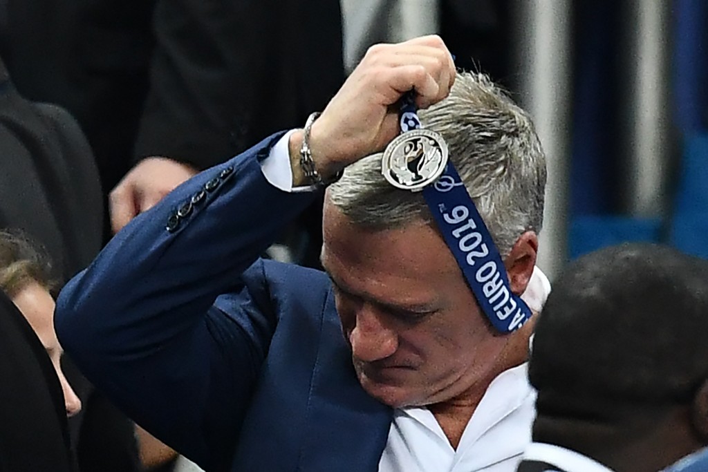 France's coach Didier Deschamps removes the looser's medal after France lost 1-0 to Portugal in the Euro 2016 final football match between France and Portugal at the Stade de France in Saint-Denis, north of Paris, on July 10, 2016. / AFP / FRANCK FIFE (Photo credit should read FRANCK FIFE/AFP/Getty Images)