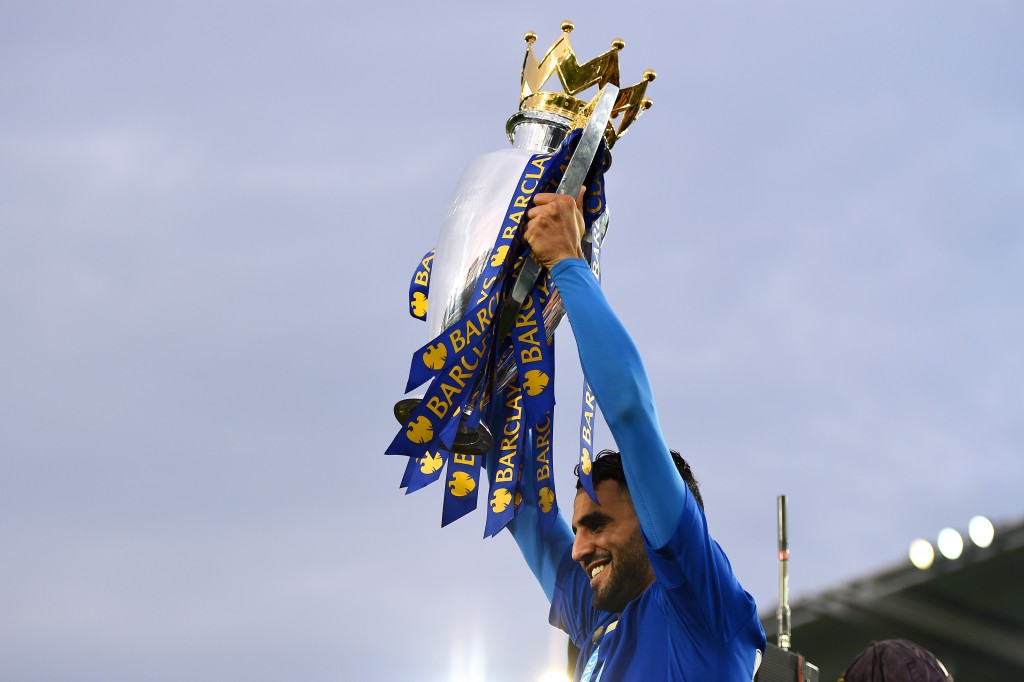 LEICESTER, ENGLAND - MAY 07: Riyad Mahrez of Leicester City lifts the Premier League Trophy as players and staffs celebrate the season champions after the Barclays Premier League match between Leicester City and Everton at The King Power Stadium on May 7, 2016 in Leicester, United Kingdom. (Photo by Laurence Griffiths/Getty Images)