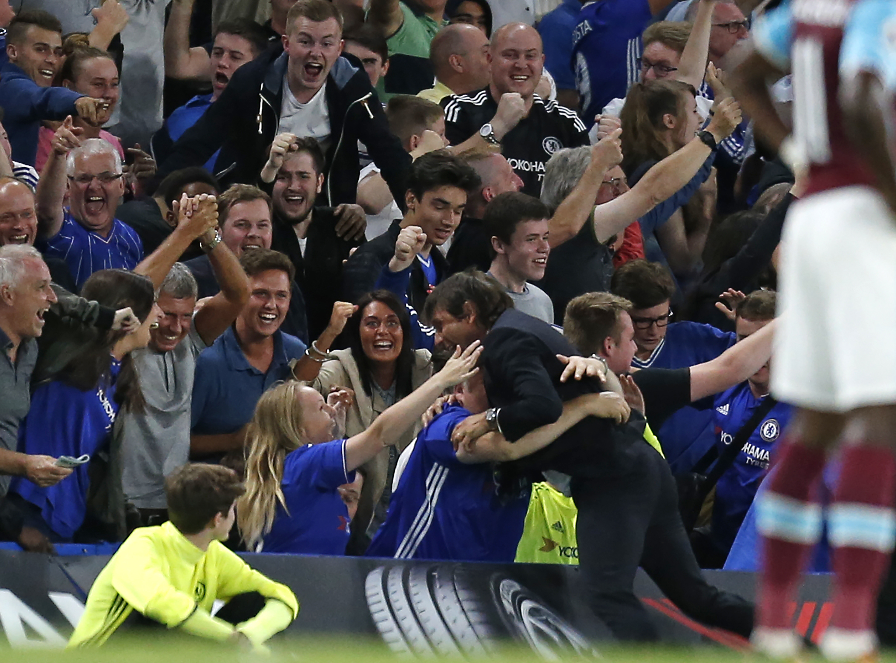 Chelsea's Italian head coach Antonio Conte celebrates with supporters after Chelsea's Brazilian-born Spanish striker Diego Costa scores their late winning goal during the English Premier League football match between Chelsea and West Ham United at Stamford Bridge in London on August 15, 2016. Chelsea won the game 2-1. / AFP / Ian KINGTON / RESTRICTED TO EDITORIAL USE. No use with unauthorized audio, video, data, fixture lists, club/league logos or 'live' services. Online in-match use limited to 75 images, no video emulation. No use in betting, games or single club/league/player publications. / (Photo credit should read IAN KINGTON/AFP/Getty Images)
