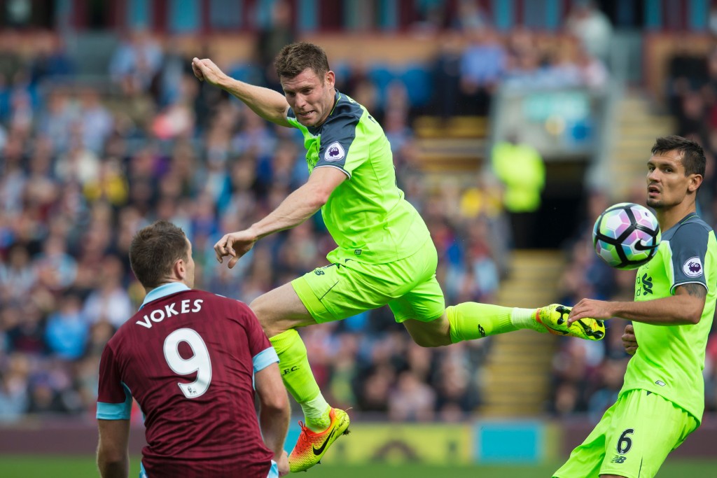 Liverpool's English midfielder James Milner jumps for the ball as Burnley's Welsh striker Sam Vokes (L) and Liverpool's Croatian defender Dejan Lovren (R) look on during the English Premier League football match between Burnley and Liverpool at Turf Moor in Burnley, north west England on August 20, 2016. / AFP / JON SUPER / RESTRICTED TO EDITORIAL USE. No use with unauthorized audio, video, data, fixture lists, club/league logos or 'live' services. Online in-match use limited to 75 images, no video emulation. No use in betting, games or single club/league/player publications. / (Photo credit should read JON SUPER/AFP/Getty Images)