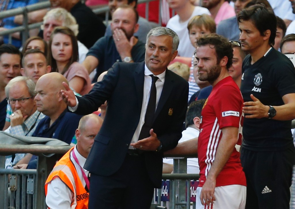 Manchester United's Spanish midfielder Juan Mata (C) talks with Manchester United's Portuguese manager Jose Mourinho (L) and Manchester United's Portuguese assistant manager Rui Faria (R) after he is substituted late on during the FA Community Shield football match between Manchester United and Leicester City at Wembley Stadium in London on August 7, 2016. (Photo credit: Ian Kington/AFP/Getty Images)