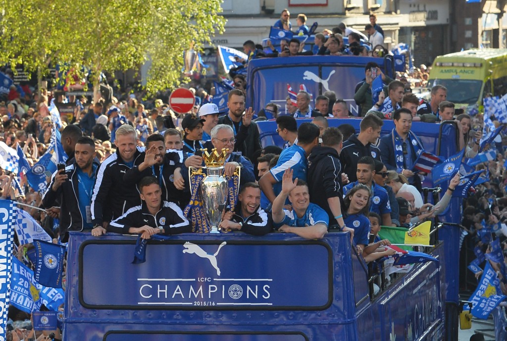 Leicester City's Italian manager Claudio Ranieri (C) stands with the Premier league trophy as the Leicester City team take part in an open-top bus parade through Leicester to celebrate winning the Premier League title on May 16, 2016. / AFP / GLYN KIRK (Photo credit should read GLYN KIRK/AFP/Getty Images)