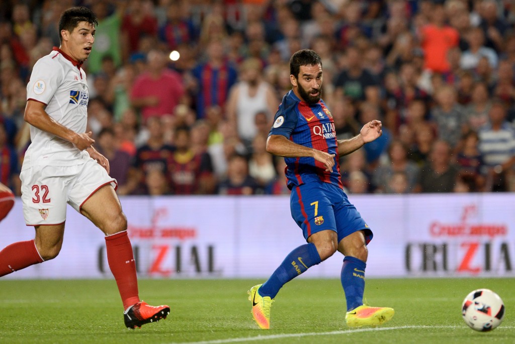 Barcelona's Turkish midfielder Arda Turan (R) scores during the second leg of the Spanish Supercup football match between FC Barcelona and Sevilla FC at the Camp Nou stadium in Barcelona on August 17, 2016. / AFP / JOSEP LAGO (Photo credit should read JOSEP LAGO/AFP/Getty Images)
