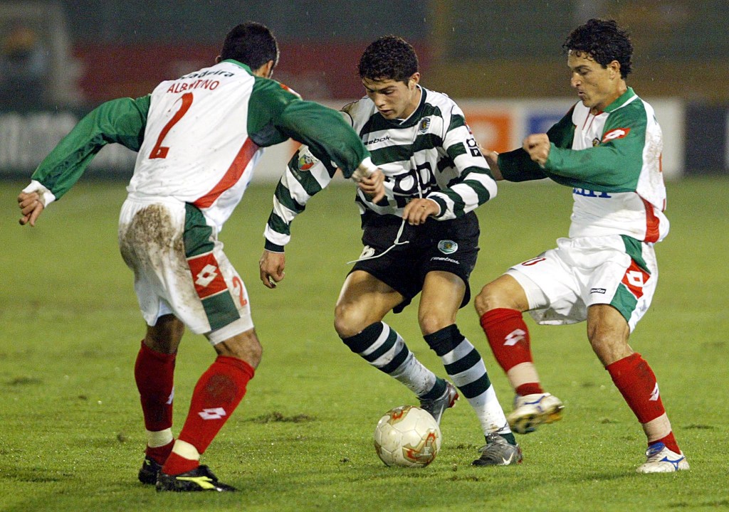 LISBON, PORTUGAL: Sporting Lisbon's Cristiano Ronaldo (C) vies with Maritimo's Albertino (L) and Joel (R) during the Portuguese league match 15 November 2002 at Alvalade Stadium in Lisbon. (Photo credit should read ANTONIO COTRIM/AFP/Getty Images)