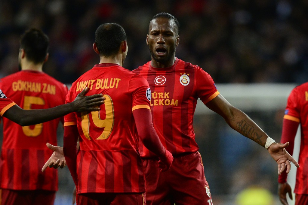 Galatasaray's striker Umut Bulut (L) celebrates with Galatasaray's Ivorian forward Didier Drogba after scoring their team first goal during the UEFA Champions League football match Real Madrid CF vs Galatasaray SK at the Santiago Bernabeu stadium in Madrid on November 27, 2013. AFP PHOTO/ JAVIER SORIANO (Photo credit should read JAVIER SORIANO/AFP/Getty Images)