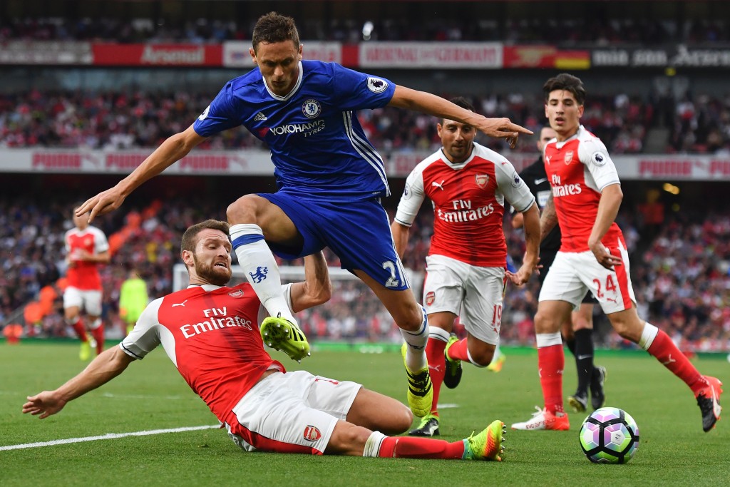 Arsenal's German defender Shkodran Mustafi (L) slides in to tackle Chelsea's Serbian midfielder Nemanja Matic (2L) during the English Premier League football match between Arsenal and Chelsea at the Emirates Stadium in London on September 24, 2016. / AFP / Ben STANSALL / RESTRICTED TO EDITORIAL USE. No use with unauthorized audio, video, data, fixture lists, club/league logos or 'live' services. Online in-match use limited to 75 images, no video emulation. No use in betting, games or single club/league/player publications. / (Photo credit should read BEN STANSALL/AFP/Getty Images)
