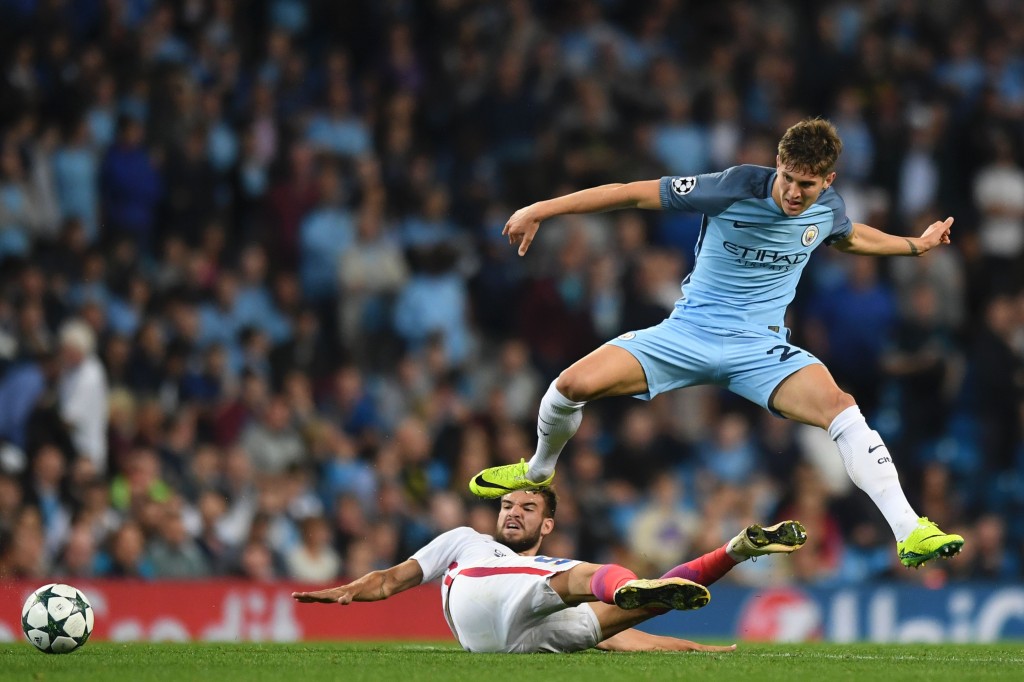 Manchester City's English defender John Stones (R) leaps a challenge from Steaua Bucharest's Romanian striker Alexandru Tudorie (L floor) during the UEFA Champions league second leg play-off football match between Manchester City and Steaua Bucharest at the Etihad Stadium in Manchester, north west England on August 24, 2016. / AFP / Anthony Devlin (Photo credit should read ANTHONY DEVLIN/AFP/Getty Images)