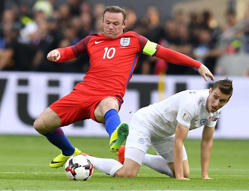 England's forward Wayne Rooney (L) vies with Slovakia's midfielder Jan Gregus during the World Cup 2018 football qualification match between Slovakia and England in Trnava, Slovakia, on September 4, 2015. (Photo by Joe Klamar/AFP/Getty Images)