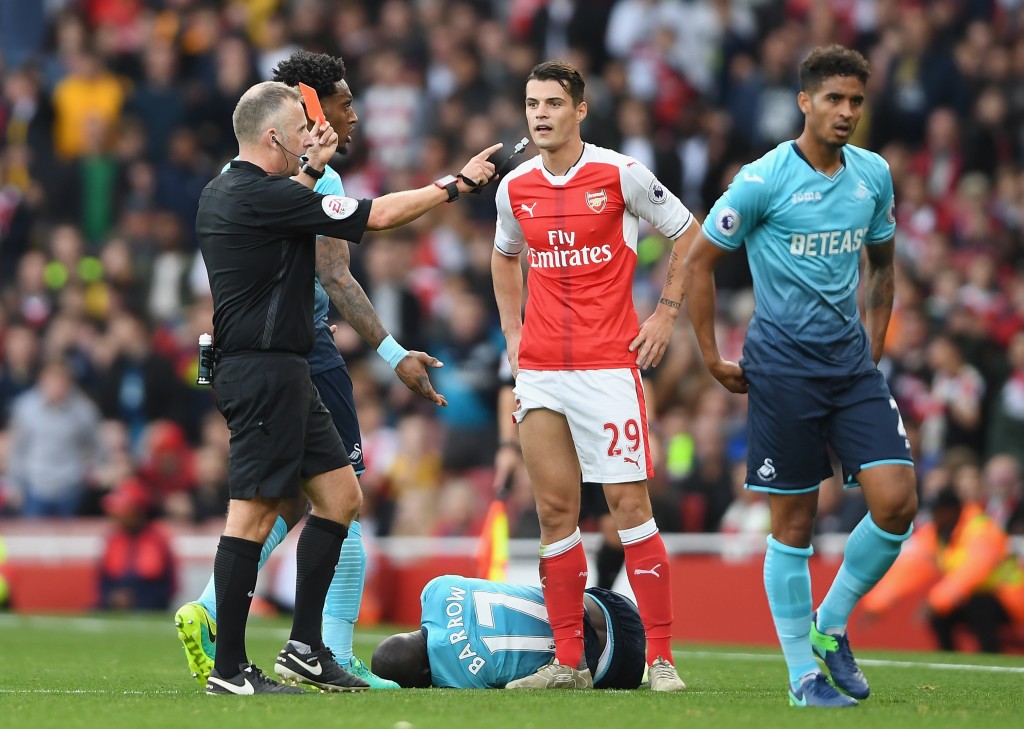 LONDON, ENGLAND - OCTOBER 15: Referee Jonanthan Moss (L) shows Granit Xhaka of Arsenal (C) a red card for a foul on Modou Barrow of Swansea City during the Premier League match between Arsenal and Swansea City at Emirates Stadium on October 15, 2016 in London, England. (Photo by Mike Hewitt/Getty Images)