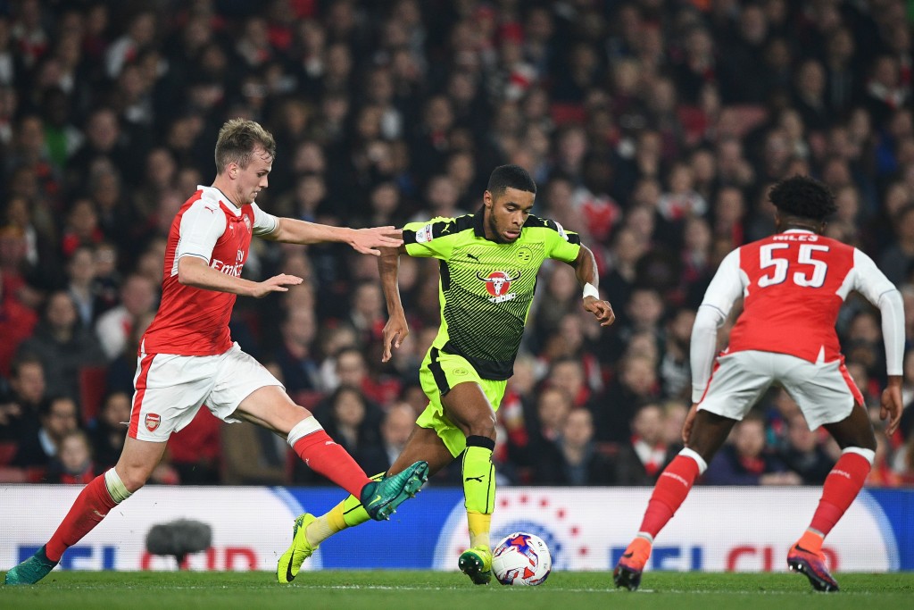 Reading's English striker Dominic Samuel (C) vies with Arsenal's English defender Rob Holding (L) and Arsenal's English midfielder Ainsley Maitland-Niles (R) during the EFL (English Football League) Cup fourth round match between Arsenal and Reading at The Emirates Stadium in London on October 25, 2016. / AFP / Justin TALLIS / RESTRICTED TO EDITORIAL USE. No use with unauthorized audio, video, data, fixture lists, club/league logos or 'live' services. Online in-match use limited to 75 images, no video emulation. No use in betting, games or single club/league/player publications. / (Photo credit should read JUSTIN TALLIS/AFP/Getty Images)