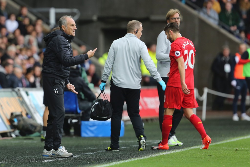 Liverpool's English midfielder Adam Lallana (R) leaves the pitch injured (R) as Swansea City's Italian head coach Francesco Guidolin (L) gestures during the English Premier League football match between Swansea City and Liverpool at The Liberty Stadium in Swansea, south Wales on October 1, 2016. / AFP / GEOFF CADDICK / RESTRICTED TO EDITORIAL USE. No use with unauthorized audio, video, data, fixture lists, club/league logos or 'live' services. Online in-match use limited to 75 images, no video emulation. No use in betting, games or single club/league/player publications. / (Photo credit should read GEOFF CADDICK/AFP/Getty Images)
