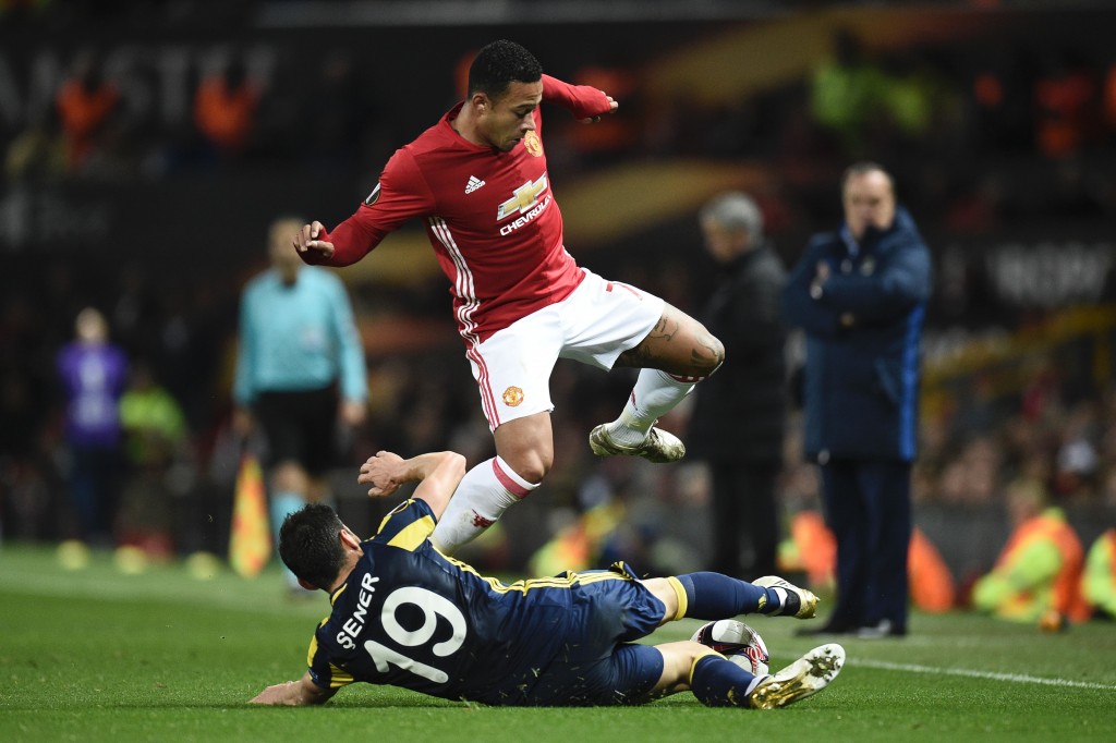 Fenerbahce's Turkish defender Sener Ozbayrakli (floor) slides to tackle Manchester United's Dutch midfielder Memphis Depay (top) during the UEFA Europa League group A football match between Manchester United and Fenerbahce at Old Trafford in Manchester, north west England, on October 20, 2016. / AFP / OLI SCARFF (Photo credit should read OLI SCARFF/AFP/Getty Images)