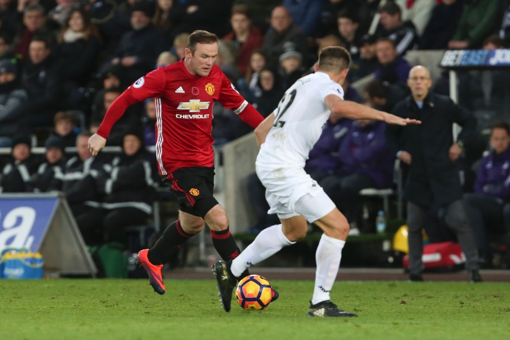 Manchester United's English striker Wayne Rooney (L) vies with Swansea City's Spanish defender Angel Rangel during the English Premier League football match between Swansea City and Manchester United at The Liberty Stadium in Swansea, south Wales on November 6, 2016. / AFP / GEOFF CADDICK / RESTRICTED TO EDITORIAL USE. No use with unauthorized audio, video, data, fixture lists, club/league logos or 'live' services. Online in-match use limited to 75 images, no video emulation. No use in betting, games or single club/league/player publications. / (Photo credit should read GEOFF CADDICK/AFP/Getty Images)