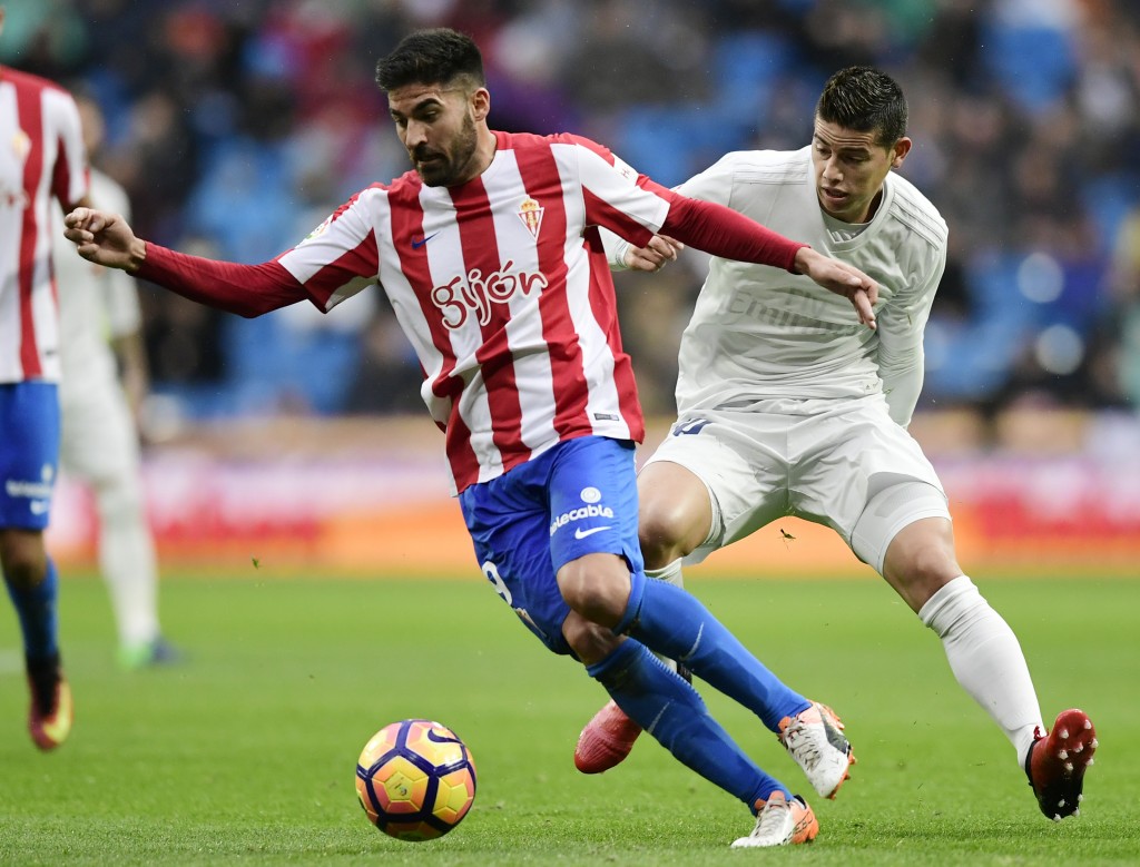 Sporting Gijon's midfielder Carlos Carmona (L) vies with Real Madrid's Colombian midfielder James Rodriguez during the Spanish league football match Real Madrid CF vs Real Sporting de Gijon at the Santiago Bernabeu stadium in Madrid on November 26, 2016. / AFP / JAVIER SORIANO (Photo credit should read JAVIER SORIANO/AFP/Getty Images)