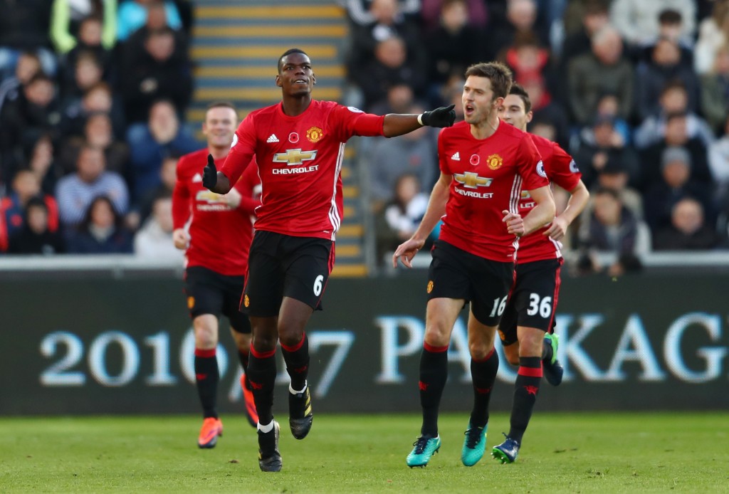 SWANSEA, WALES - NOVEMBER 06: Paul Pogba of Manchester United celebrates scoring his sides first goal with Michael Carrick during the Premier League match between Swansea City and Manchester United at Liberty Stadium on November 6, 2016 in Swansea, Wales. (Photo by Michael Steele/Getty Images)