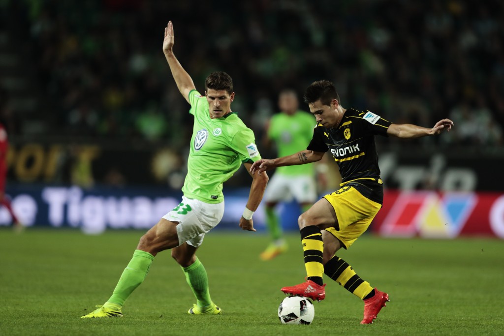 WOLFSBURG, GERMANY - SEPTEMBER 20: Mario Gomez (L) of Wolfsburg and Raphael Guerreiro (R) of Dortmund compete for the ball during the Bundesliga match between VfL Wolfsburg and Borussia Dortmund at Volkswagen Arena on September 20, 2016 in Wolfsburg, Germany. (Photo by Oliver Hardt/Bongarts/Getty Images)