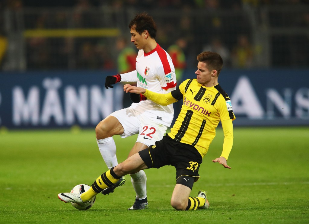 DORTMUND, GERMANY - DECEMBER 20: Dong-Won Ji of FC Augsburg is tackled by Julian Weigl of Borussia Dortmund during the Bundesliga match between Borussia Dortmund and FC Augsburg at Signal Iduna Park on December 20, 2016 in Dortmund, Germany. (Photo by Dean Mouhtaropoulos/Bongarts/Getty Images)