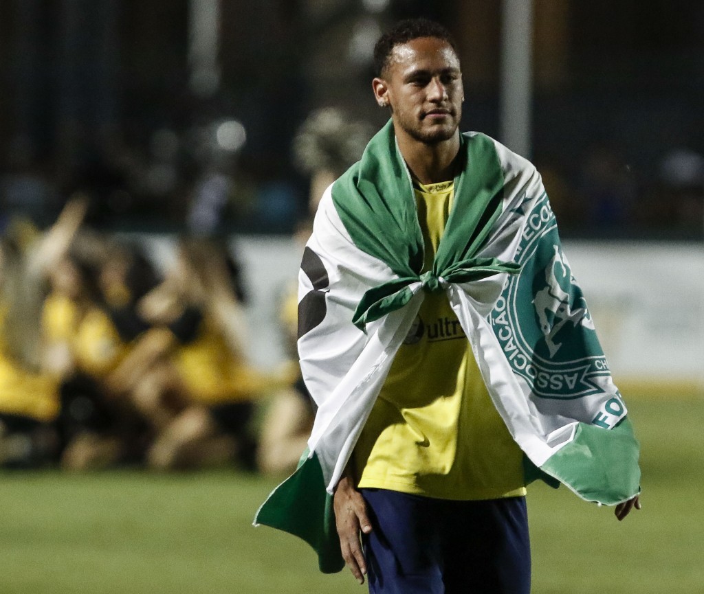 Brazil's Neymar of Spanish team Barcelona uses a flag in tribute to the victims of the November 28, 2016 Colombia plane crash that killed nearly the entire Brazilian Chapecoense football team during the charity football match Ousadia vs Pedalada at Pacaembu stadium in Sao Paulo, on December 22, 2016. Donations will go to the Neymar Jr. Project Institute in Praia Grande, São Paulo. (Photo by Miguel Schincariol/AFP/Getty Images)