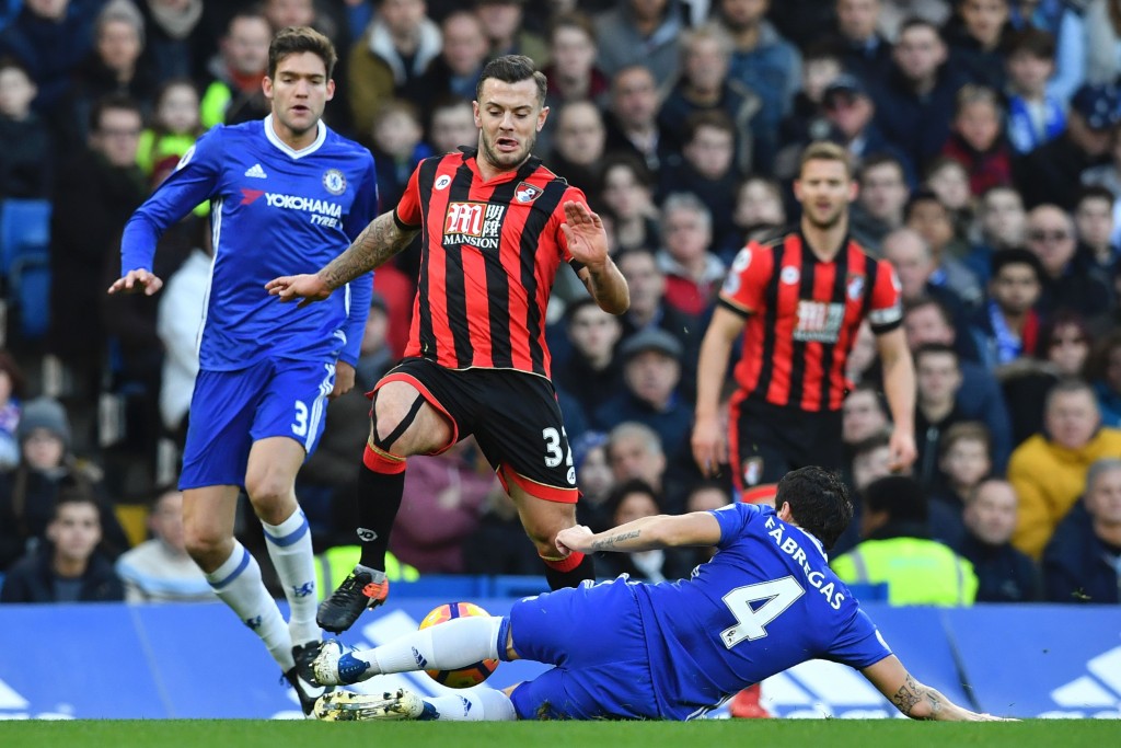 Chelsea's Spanish midfielder Cesc Fabregas (R floor) tackles Bournemouth's English midfielder Jack Wilshere (2L) during the English Premier League football match between Chelsea and Bournemouth at Stamford Bridge in London on December 26, 2016. / AFP / Ben STANSALL / RESTRICTED TO EDITORIAL USE. No use with unauthorized audio, video, data, fixture lists, club/league logos or 'live' services. Online in-match use limited to 75 images, no video emulation. No use in betting, games or single club/league/player publications. / (Photo credit should read BEN STANSALL/AFP/Getty Images)