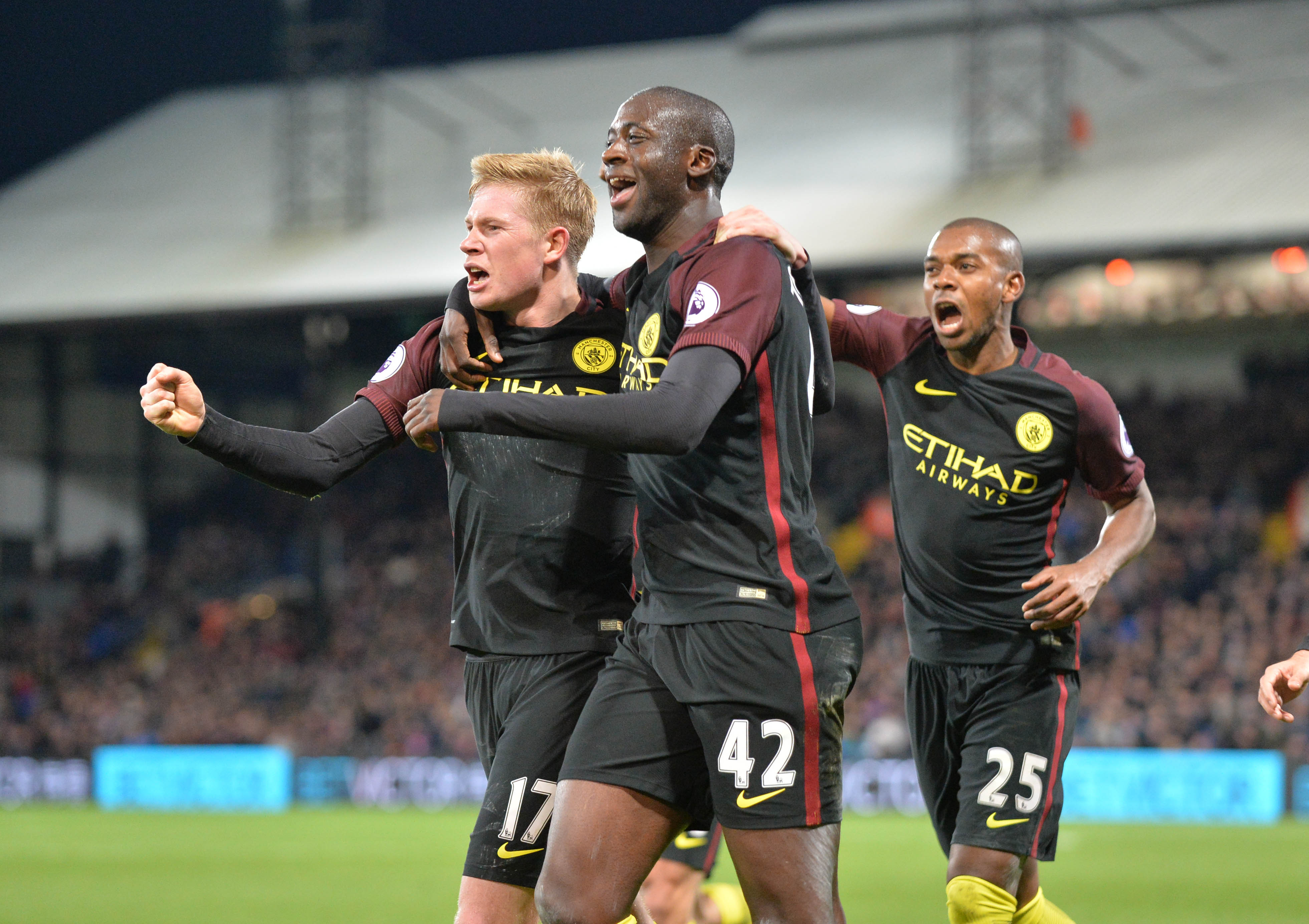 Manchester City's Ivorian midfielder Yaya Toure (C) celebrates with Manchester City's Belgian midfielder Kevin De Bruyne (L) and Manchester City's Brazilian midfielder Fernandinho (R) after scoring their second goal during the English Premier League football match between Crystal Palace and Manchester City at Selhurst Park in south London on November 19, 2016. Manchester City won the game 2-1. / AFP / OLLY GREENWOOD / RESTRICTED TO EDITORIAL USE. No use with unauthorized audio, video, data, fixture lists, club/league logos or 'live' services. Online in-match use limited to 75 images, no video emulation. No use in betting, games or single club/league/player publications. / (Photo credit should read OLLY GREENWOOD/AFP/Getty Images)