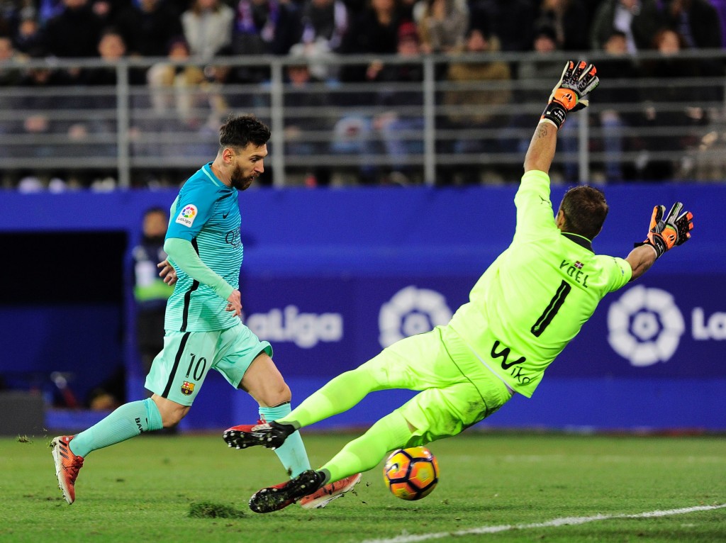 Barcelona's Argentinian forward Lionel Messi (L) shoots to score during the Spanish league football match SD Eibar vs FC Barcelona at the Ipurua stadium in Eibar on January 22, 2017. / AFP / ANDER GILLENEA (Photo credit should read ANDER GILLENEA/AFP/Getty Images)