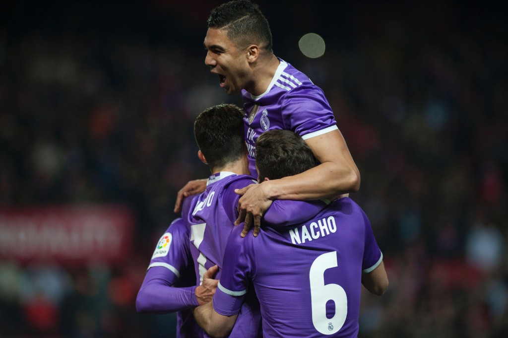 Real Madrid's Portuguese forward Cristiano Ronaldo (L) celebrates with Real Madrid's Brazilian midfielder Casemiro (up) after scoring during the Spanish league football match Sevilla FC vs Real Madrid CF at the Ramon Sanchez Pizjuan stadium in Sevilla on January 15, 2017. Sevilla won 2-1. / AFP / JORGE GUERRERO (Photo credit should read JORGE GUERRERO/AFP/Getty Images)
