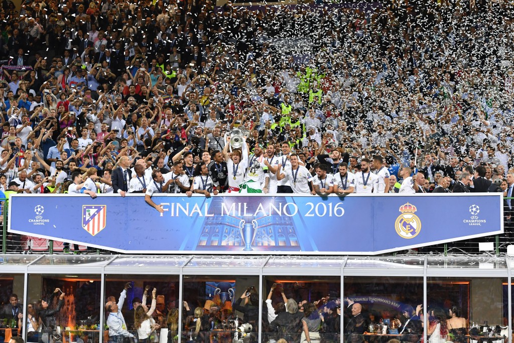 Real Madrid's Croatian midfielder Luka Modric (C) lifts the trophy as Real Madrid players celebrate winning the UEFA Champions League final football match over Atletico Madrid at San Siro Stadium in Milan, on May 28, 2016. / AFP / GERARD JULIEN (Photo credit should read GERARD JULIEN/AFP/Getty Images)
