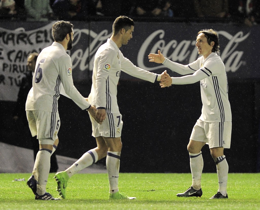 (L-R) Real Madrid's defender Nacho Fernandez, Portuguese forward Cristiano Ronaldo and Croatian midfielder Luka Modric celebrate after forward Lucas Vazquez scoring his team's third goal during the Spanish league football match CA Osasuna vs Real Madrid CF at El Sadar stadium in Pamplona on February 11, 2017. / AFP / ANDER GILLENEA (Photo credit should read ANDER GILLENEA/AFP/Getty Images)