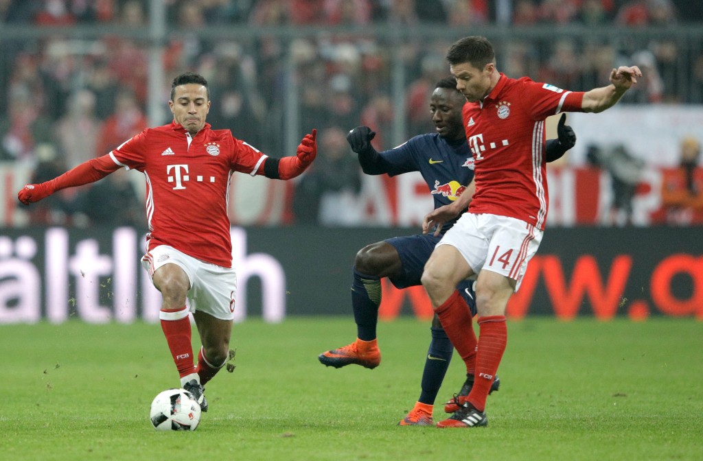 MUNICH, GERMANY - DECEMBER 21: Thiago Alcantara of Bayern Muenchen (L) and Xabi Alonso of Bayern Muenchen (R) battle with Naby Deco Keita of RB Leipzig (C) during the Bundesliga match between Bayern Muenchen and RB Leipzig at Allianz Arena on December 21, 2016 in Munich, Germany. (Photo by Adam Pretty/Bongarts/Getty Images)
