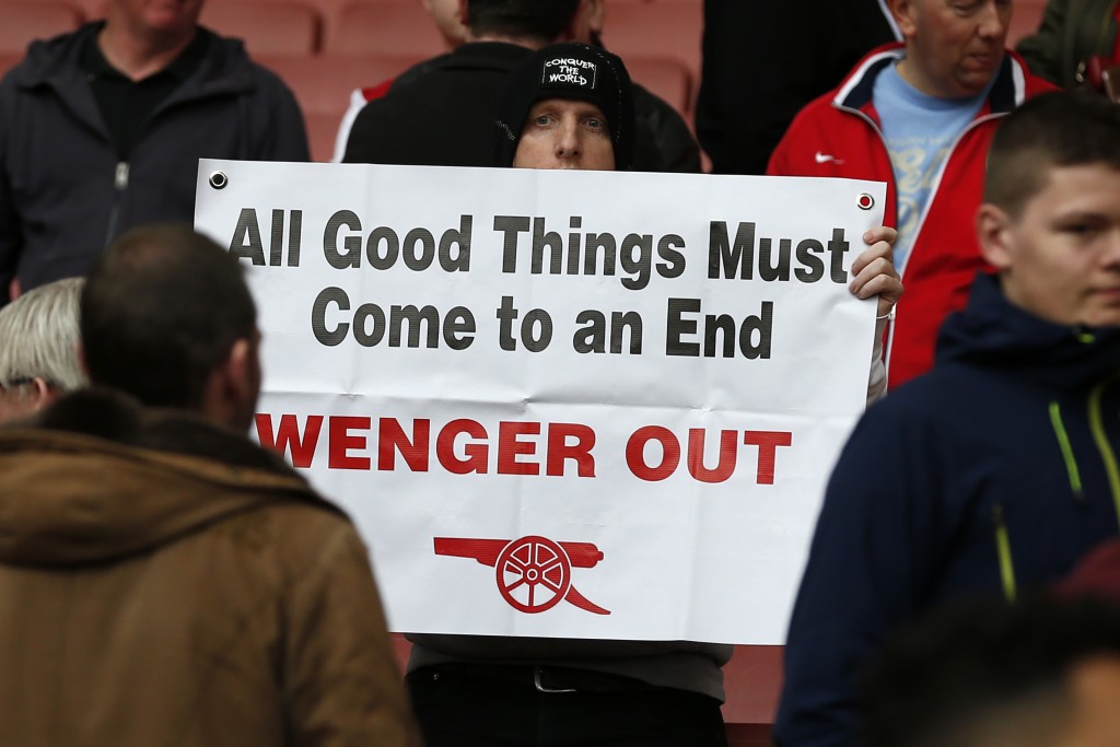A supporter holds up an anti-Wenger placard in the crowd after the English Premier League football match between Arsenal and Manchester City at The Emirates in London. (Photo courtesy - Ian Kington/AFP/Getty Images)