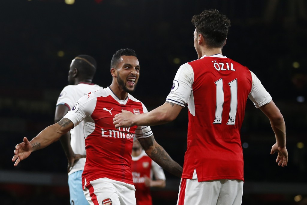 Arsenal's English midfielder Theo Walcott (L) with Mesut Ozil. / AFP PHOTO / Ian KINGTON / RESTRICTED TO EDITORIAL USE. No use with unauthorized audio, video, data, fixture lists, club/league logos or 'live' services. Online in-match use limited to 75 images, no video emulation. No use in betting, games or single club/league/player publications. / (Photo credit should read IAN KINGTON/AFP/Getty Images)