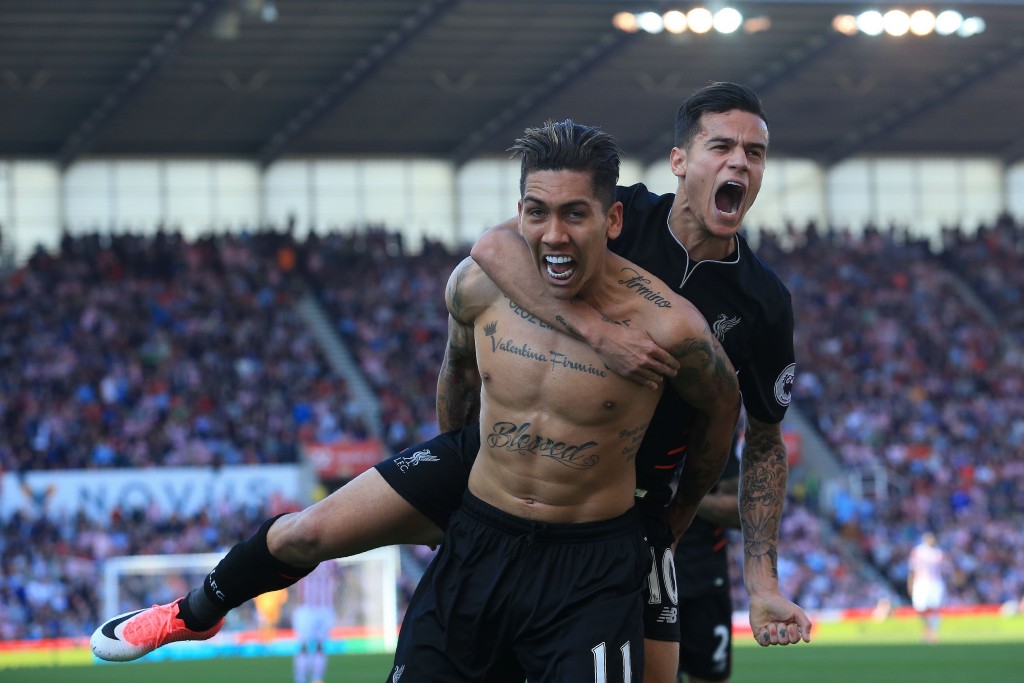 Liverpool's Brazilian midfielder Roberto Firmino (L) celebrates scoring his team's second goal with Liverpool's Brazilian midfielder Philippe Coutinho during the English Premier League football match between Stoke City and Liverpool at the Bet365 Stadium in Stoke-on-Trent, central England on April 8, 2017. / AFP PHOTO / Lindsey PARNABY / RESTRICTED TO EDITORIAL USE. No use with unauthorized audio, video, data, fixture lists, club/league logos or 'live' services. Online in-match use limited to 75 images, no video emulation. No use in betting, games or single club/league/player publications. / (Photo credit should read LINDSEY PARNABY/AFP/Getty Images)