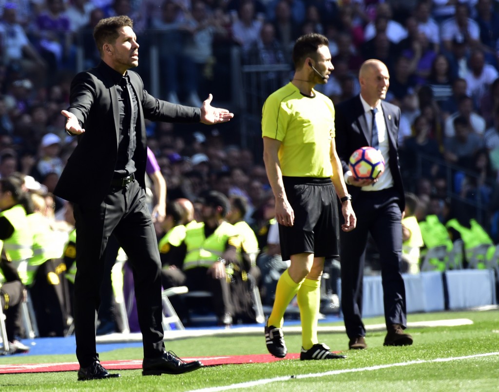 Atletico Madrid's Argentinian coach Diego Simeone (L) gestures close to Real Madrid's French coach Zinedine Zidane during the Spanish league football match Real Madrid CF vs Club Atletico de Madrid at the Santiago Bernabeu stadium in Madrid on April, 8, 2017. / AFP PHOTO / GERARD JULIEN (Photo credit should read GERARD JULIEN/AFP/Getty Images)