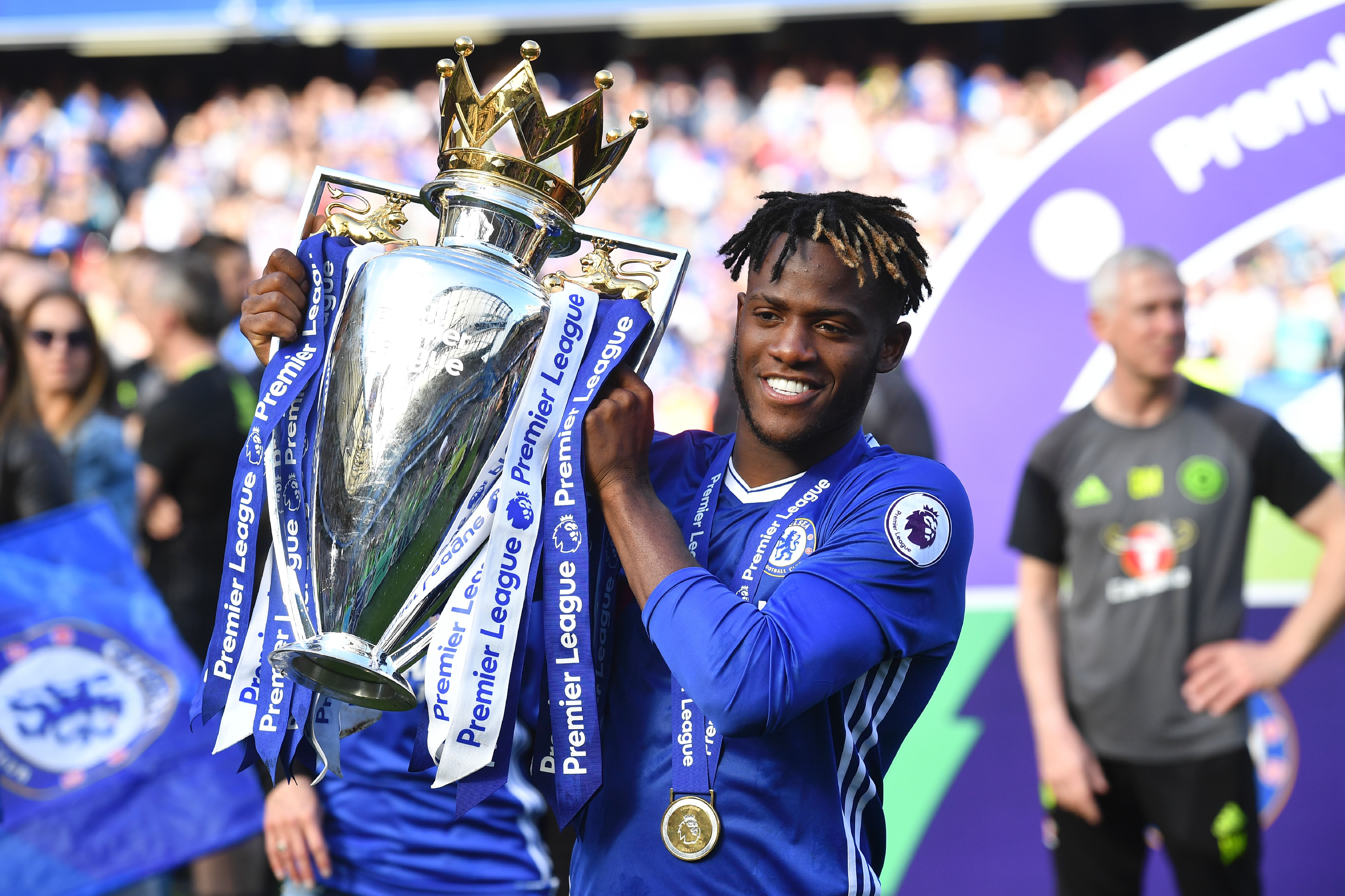 Chelsea's Belgian striker Michy Batshuayi poses with the English Premier League trophy, as players celebrate their league title win at the end of the Premier League football match between Chelsea and Sunderland at Stamford Bridge in London on May 21, 2017. Chelsea's extended victory parade reached a climax with the trophy presentation on May 21, 2017 after being crowned Premier League champions with two games to go. / AFP PHOTO / Ben STANSALL / RESTRICTED TO EDITORIAL USE. No use with unauthorized audio, video, data, fixture lists, club/league logos or 'live' services. Online in-match use limited to 75 images, no video emulation. No use in betting, games or single club/league/player publications. / (Photo credit should read BEN STANSALL/AFP/Getty Images)