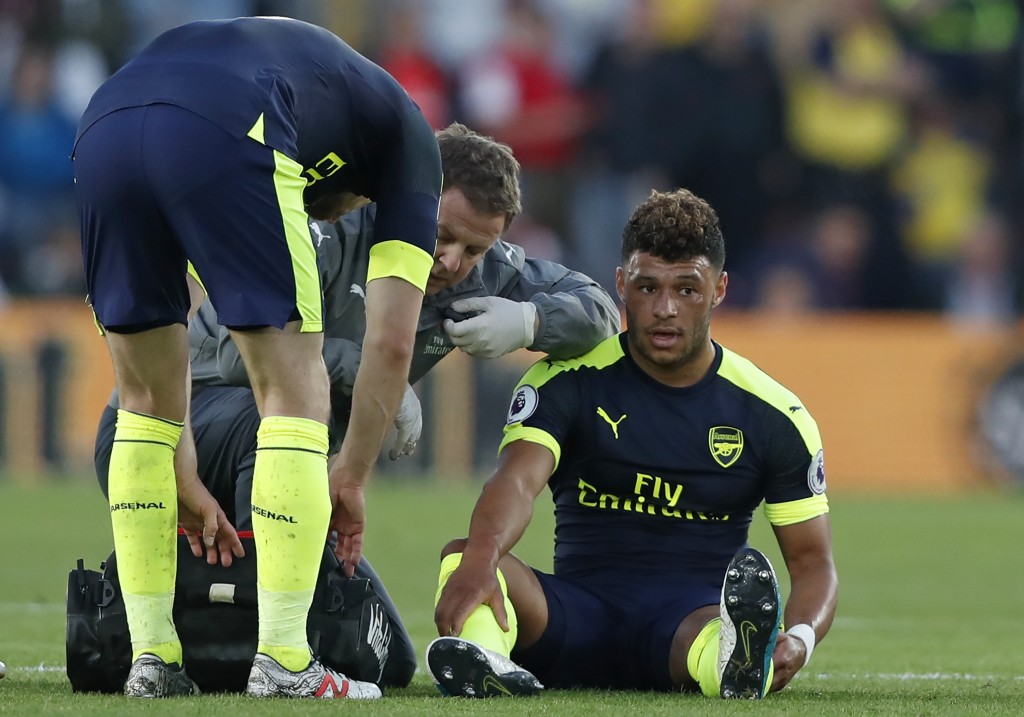 Arsenal's English midfielder Alex Oxlade-Chamberlain (R) receives medical attention after picking up an injury during the English Premier League football match between Southampton and Arsenal at St Mary's Stadium in Southampton, southern England on May 10, 2017. / AFP PHOTO / Adrian DENNIS / RESTRICTED TO EDITORIAL USE. No use with unauthorized audio, video, data, fixture lists, club/league logos or 'live' services. Online in-match use limited to 75 images, no video emulation. No use in betting, games or single club/league/player publications. / (Photo credit should read ADRIAN DENNIS/AFP/Getty Images)