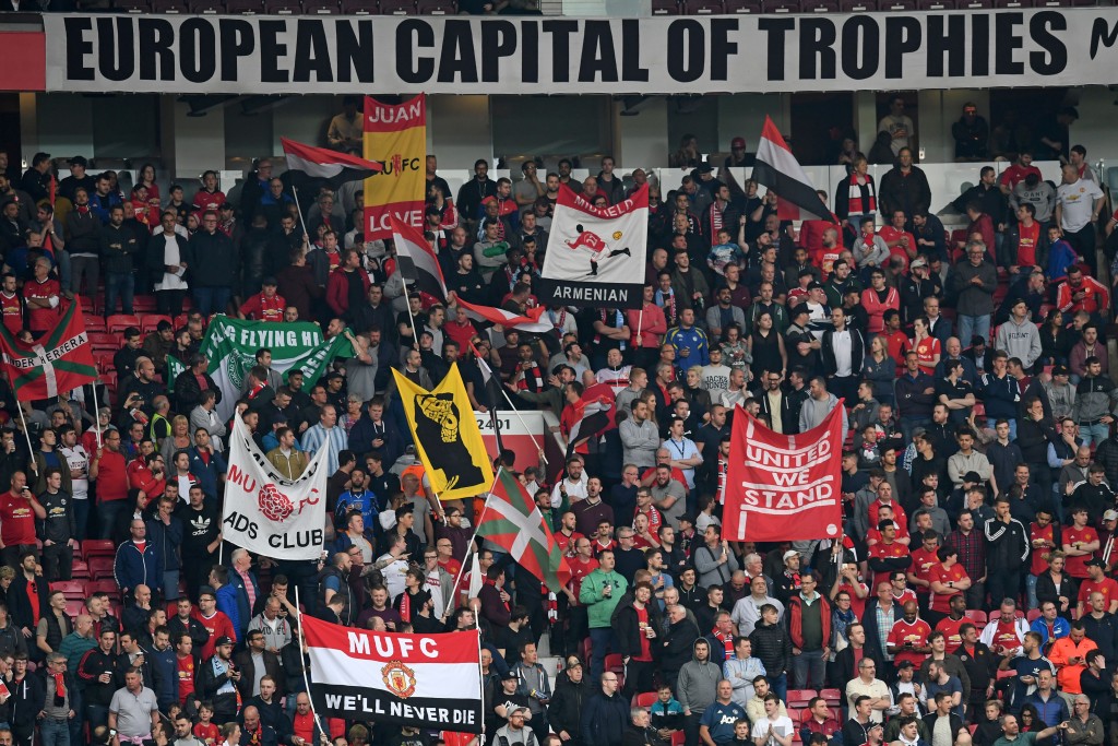 Manchester United supporters hold up banners in the crowd ahead of the UEFA Europa League semi-final, second-leg football match between Manchester United and Celta Vigo at Old Trafford stadium in Manchester, north-west England, on May 11, 2017. / AFP PHOTO / Paul ELLIS (Photo credit should read PAUL ELLIS/AFP/Getty Images)