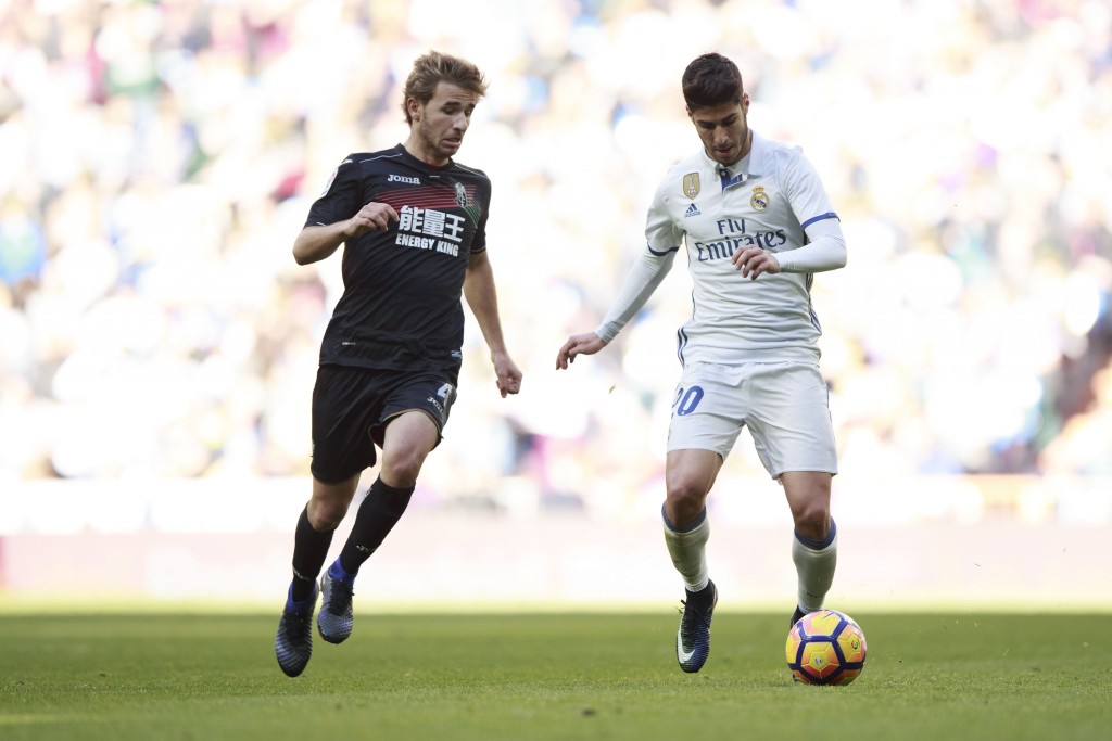 MADRID, SPAIN - JANUARY 07: Marco Asensio (R) of Real Madrid CF competes for the ball with Sergi Samper (L) of Granada CF during the La Liga match between Real Madrid CF and Granada CF at Estadio Santiago Bernabeu on January 7, 2017 in Madrid, Spain. (Photo by Gonzalo Arroyo Moreno/Getty Images)