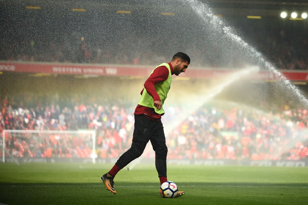 Liverpool's German midfielder Emre Can warms up as the pitch is watered at half time in the English Premier League football match between Liverpool and Crystal Palace at Anfield in Liverpool, north west England on August 19, 2017. / AFP PHOTO / Oli SCARFF / RESTRICTED TO EDITORIAL USE. No use with unauthorized audio, video, data, fixture lists, club/league logos or 'live' services. Online in-match use limited to 75 images, no video emulation. No use in betting, games or single club/league/player publications. / (Photo credit should read OLI SCARFF/AFP/Getty Images)