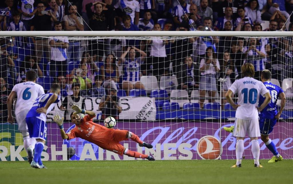 Real Madrid's Costa Rican goalkeeper Keylor Navas stops a penalty shot by Deportivo La Coruna's Romanian forward Florin Andone (R) during the Spanish league footbal match RC Deportivo de la Coruna vs Real Madrid CF at the Municipal de Riazor stadium in La Coruna on August 20, 2017. / AFP PHOTO / MIGUEL RIOPA (Photo credit should read MIGUEL RIOPA/AFP/Getty Images)
