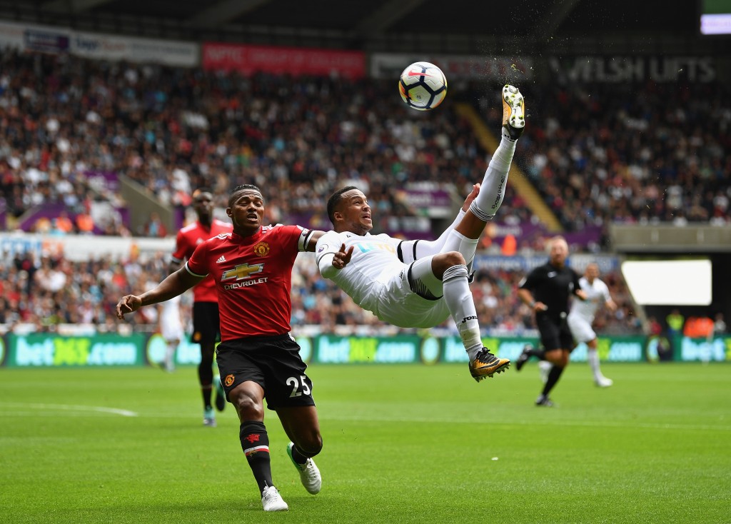 SWANSEA, WALES - AUGUST 19: Martin Olsson of Swansea City attempts a over head kick as Antonio Valencia of Manchester Uited puts pressure on him during the Premier League match between Swansea City and Manchester United at Liberty Stadium on August 19, 2017 in Swansea, Wales. (Photo by Dan Mullan/Getty Images)