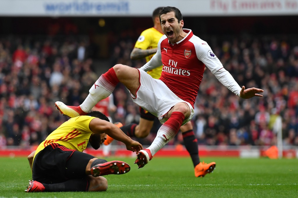 TOPSHOT - Arsenal's Armenian midfielder Henrikh Mkhitaryan reacts to a challenge from Watford's English-born Jamaican defender Adrian Mariappa (L) during the English Premier League football match between Arsenal and Watford at the Emirates Stadium in London on March 11, 2018. / AFP PHOTO / Ben STANSALL / RESTRICTED TO EDITORIAL USE. No use with unauthorized audio, video, data, fixture lists, club/league logos or 'live' services. Online in-match use limited to 75 images, no video emulation. No use in betting, games or single club/league/player publications. / (Photo credit should read BEN STANSALL/AFP/Getty Images)