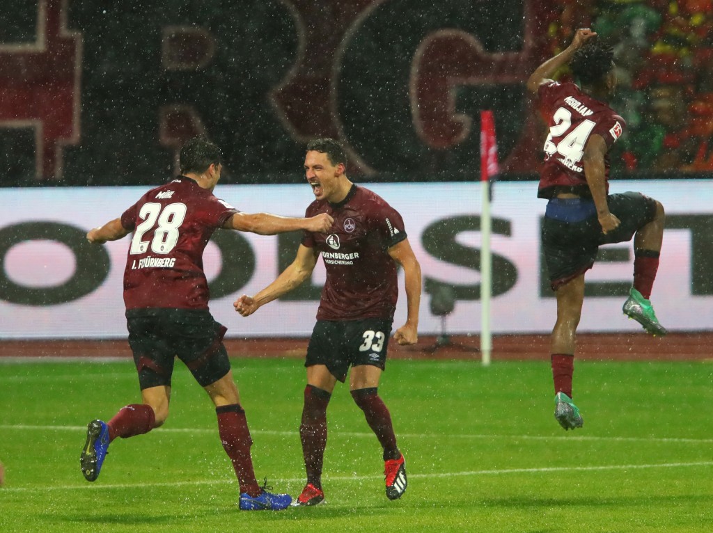 NUREMBERG, GERMANY - DECEMBER 03: Georg Margreitter of Nuernberg (33) celebrates after scoring his team's first goal with Lukas Muehl (28) and Virgil Misidjan (24) during the Bundesliga match between 1. FC Nuernberg and Bayer 04 Leverkusen at Max-Morlock-Stadion on December 3, 2018 in Nuremberg, Germany. (Photo by Alexander Hassenstein/Bongarts/Getty Images)